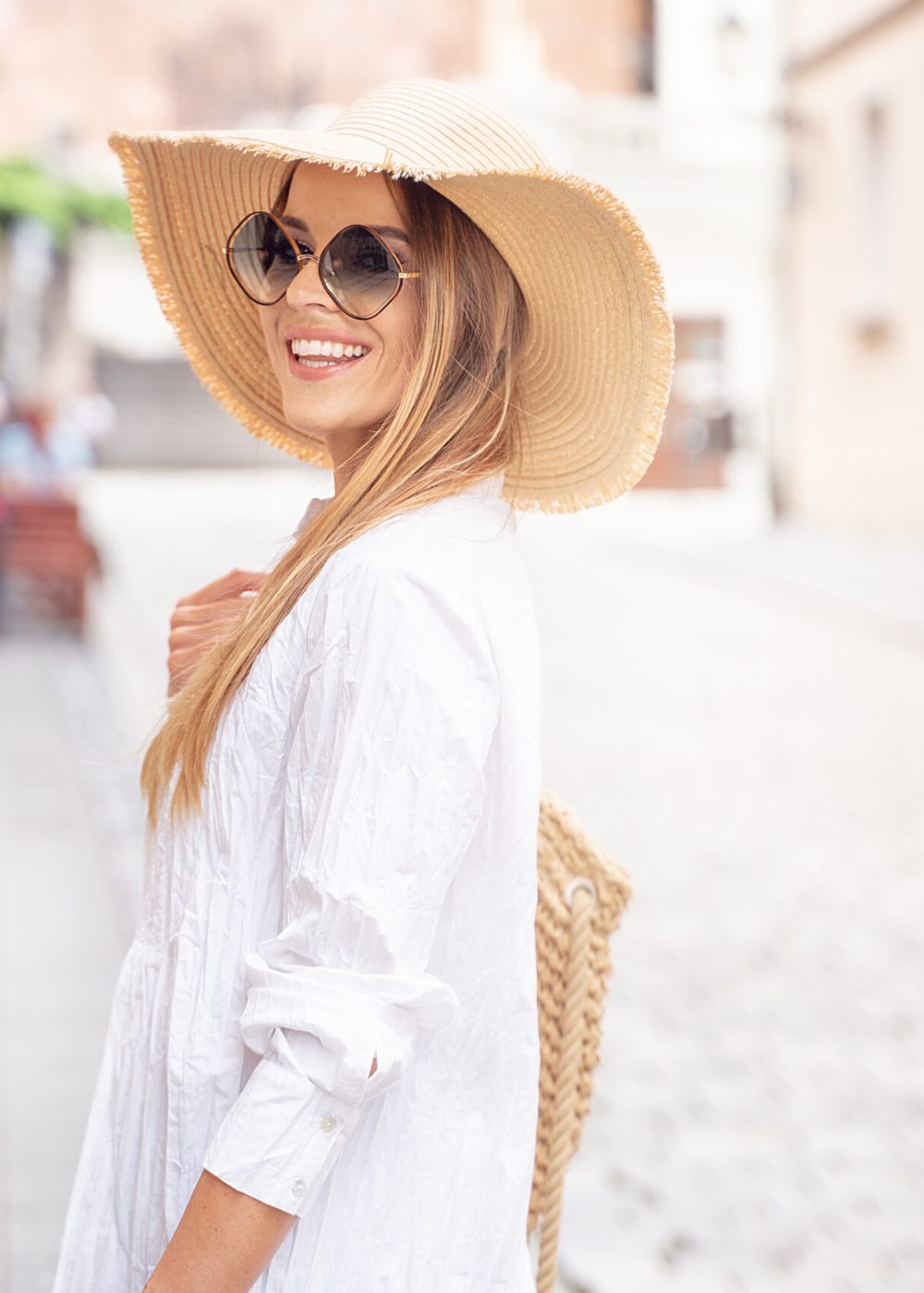 Young beautiful happy woman on vacation wearing summer hat and fashionable sunglasses.